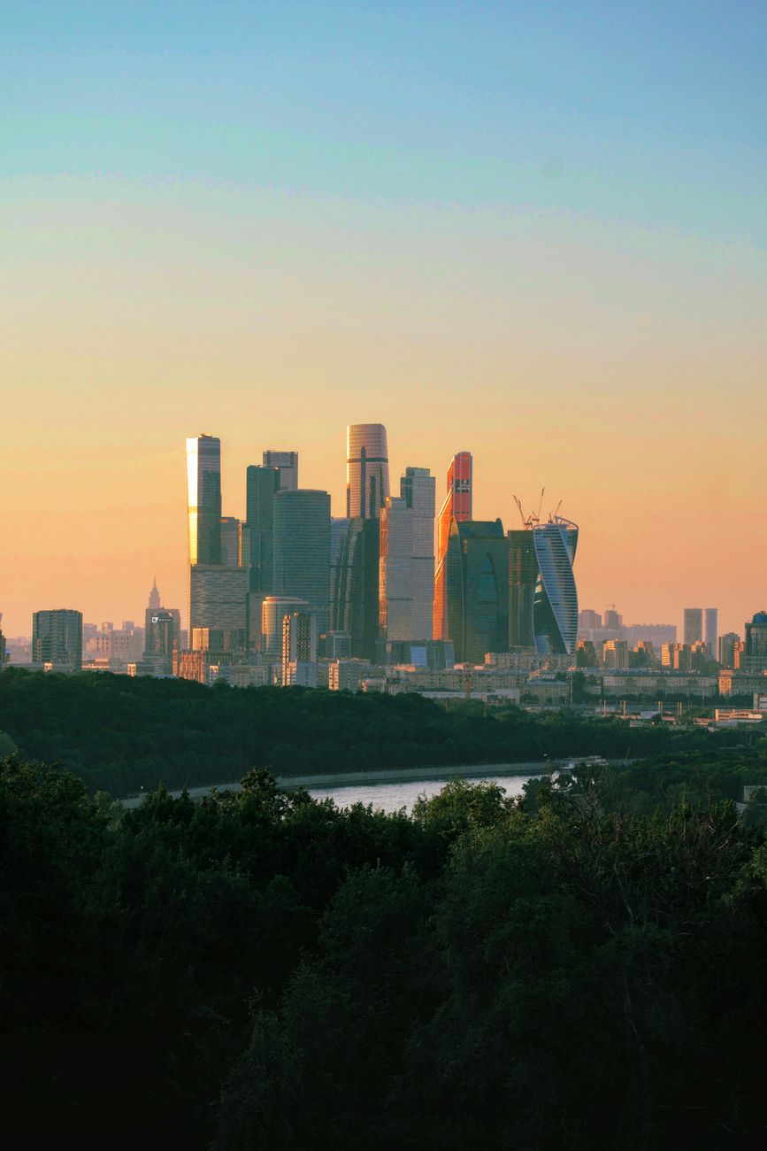 A panoramic view of a gleaming, futuristic city skyline at dawn, symbolizing the bright future of AI-enhanced human health and wellness.